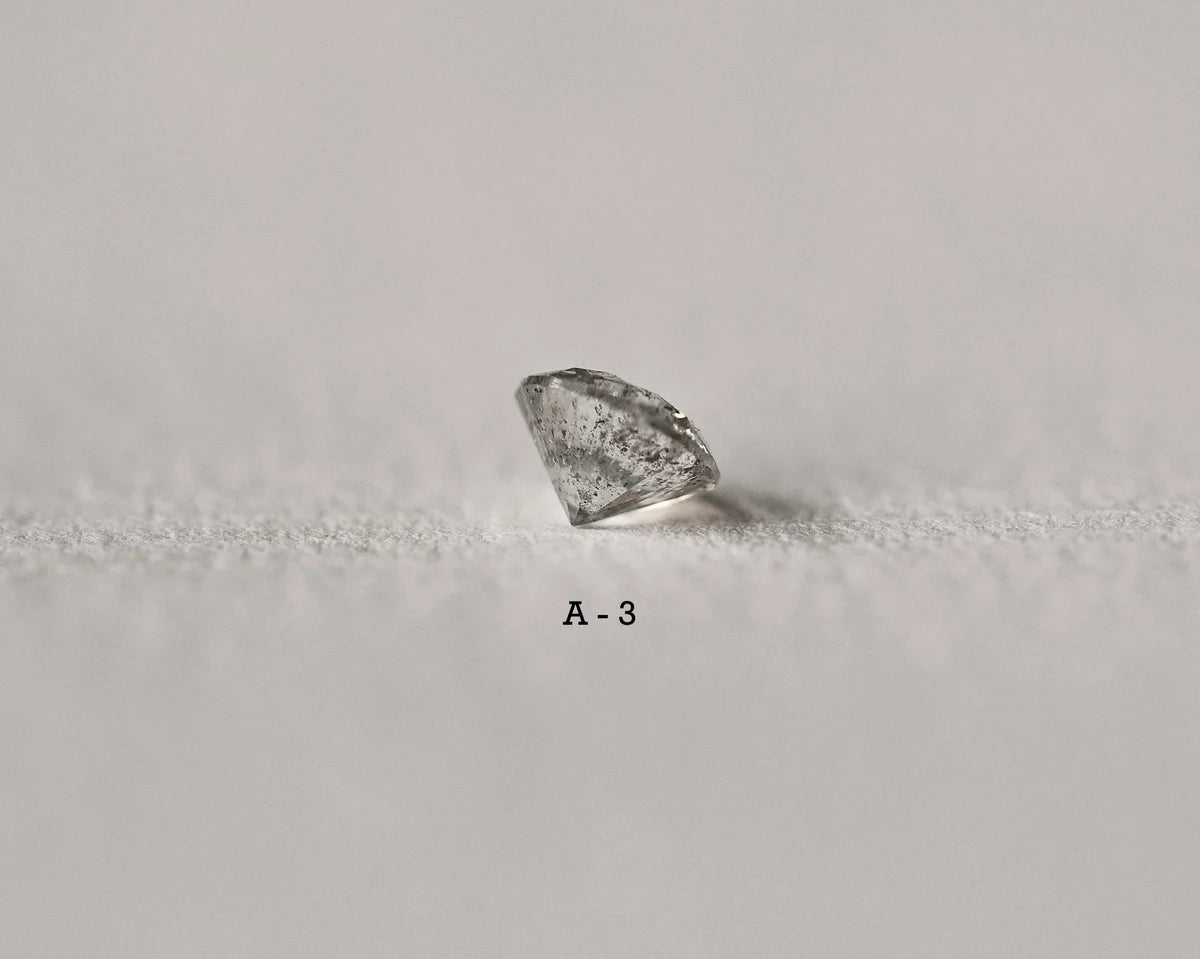 Raw diamond on a textured gray surface with 'A-3' label.