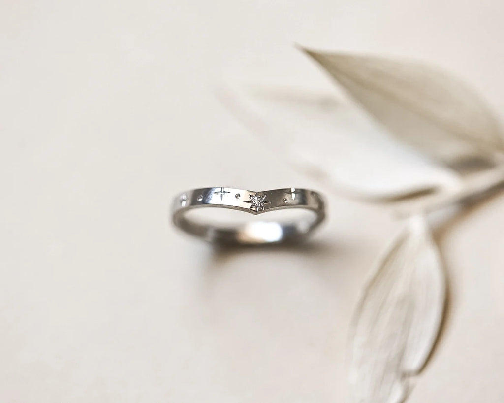 Soft focus view of platinum star set diamond wishbone ring