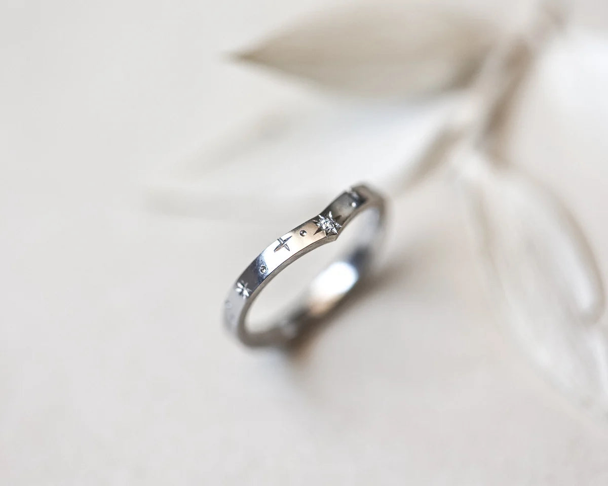 Detailed view of star engraving and diamond setting on platinum wishbone ring