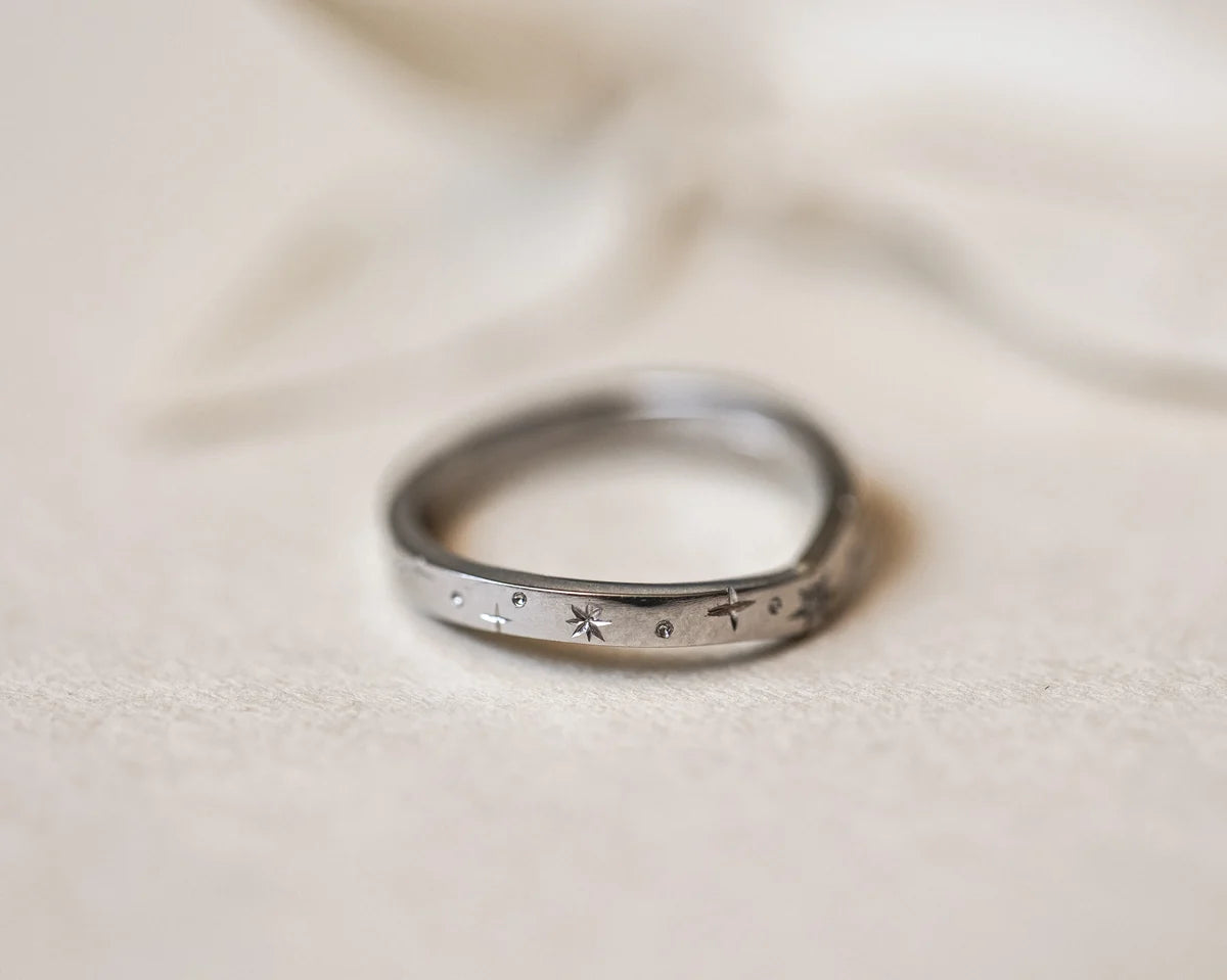 Angled view of handmade platinum star set diamond wishbone ring