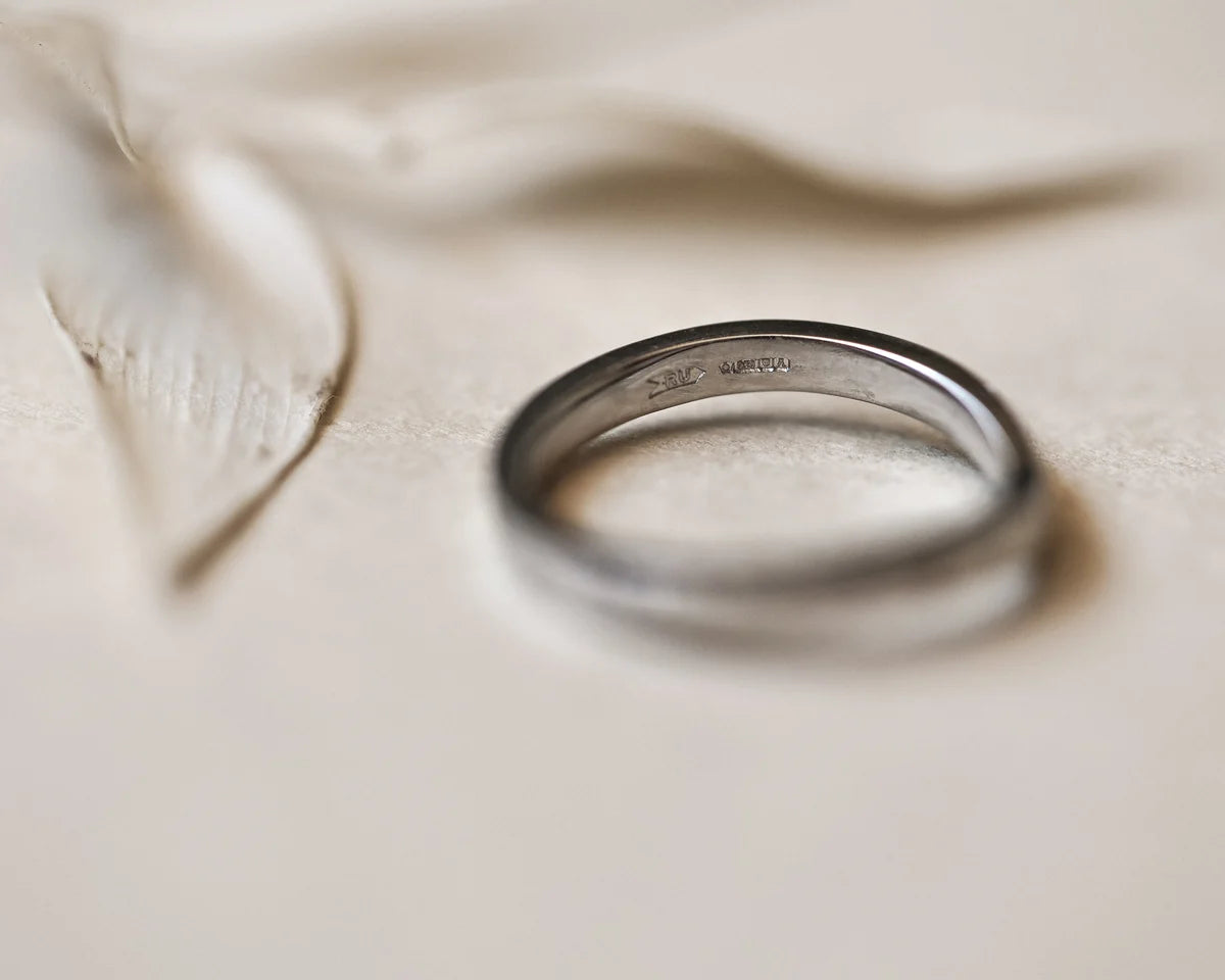 Silver ring on a soft beige fabric background