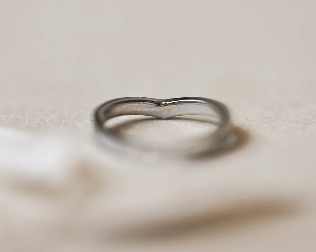 Silver ring on a textured beige surface