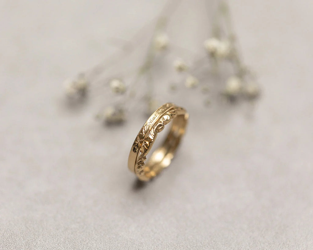 two gold engraved and carved wedding rings