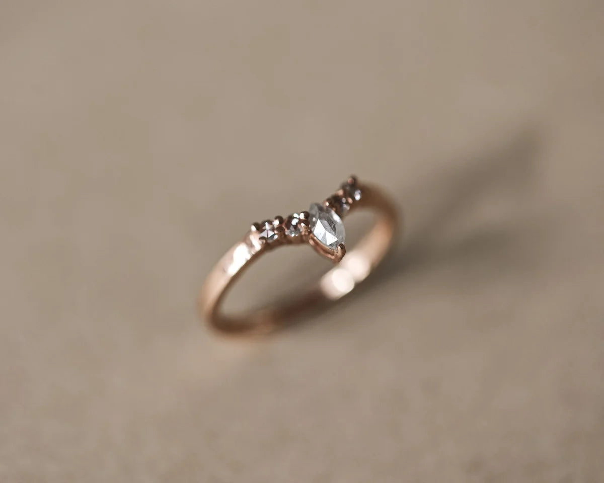 Soft focus view of milky grey marquise diamond ring in rose gold