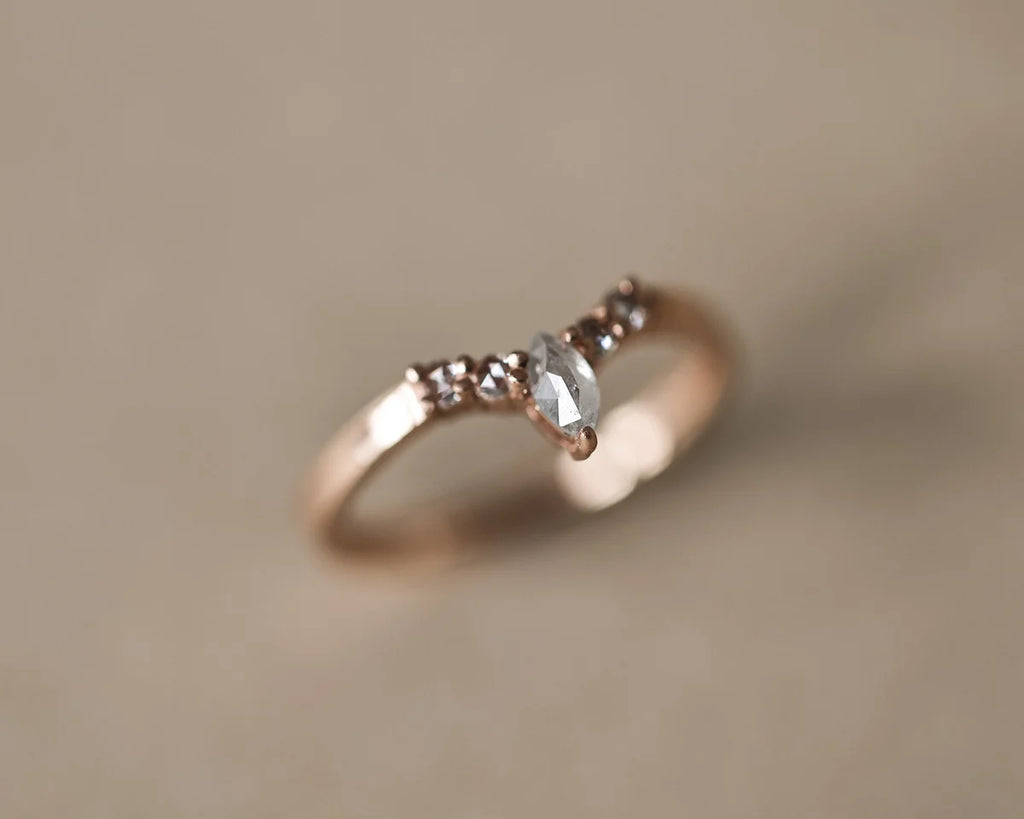Angled close-up of rose gold wishbone ring with marquise centre diamond