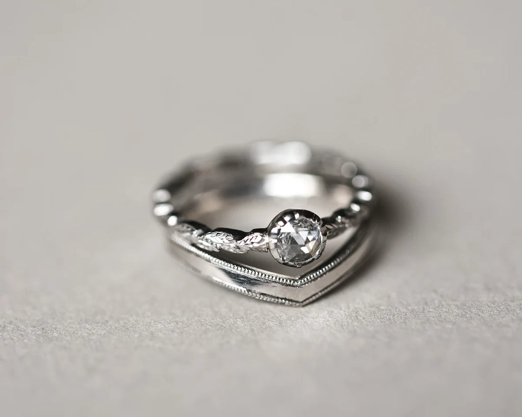 Milled edge platinum wishbone ring stacked with diamond engagement ring