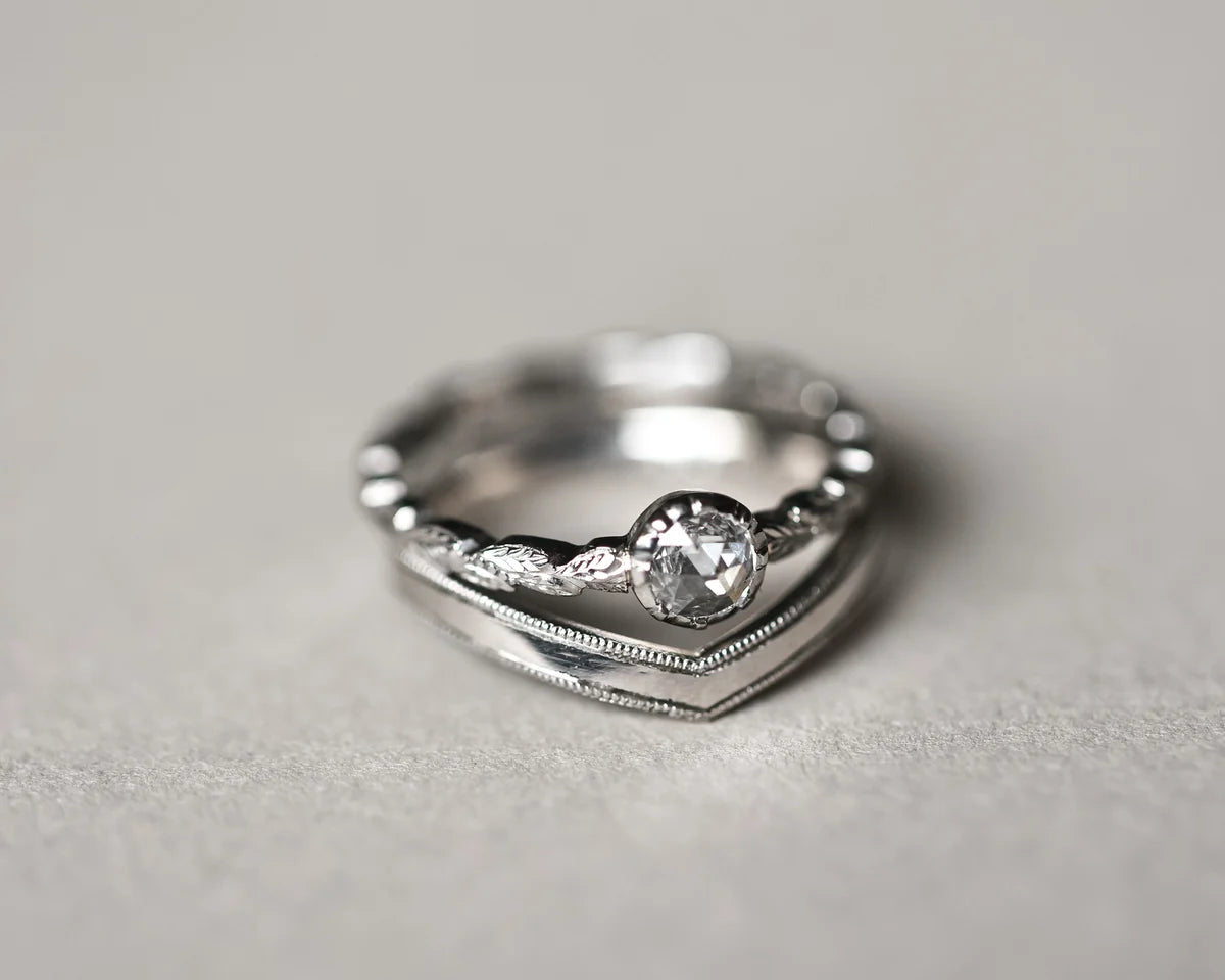 Milled edge platinum wishbone ring stacked with diamond engagement ring