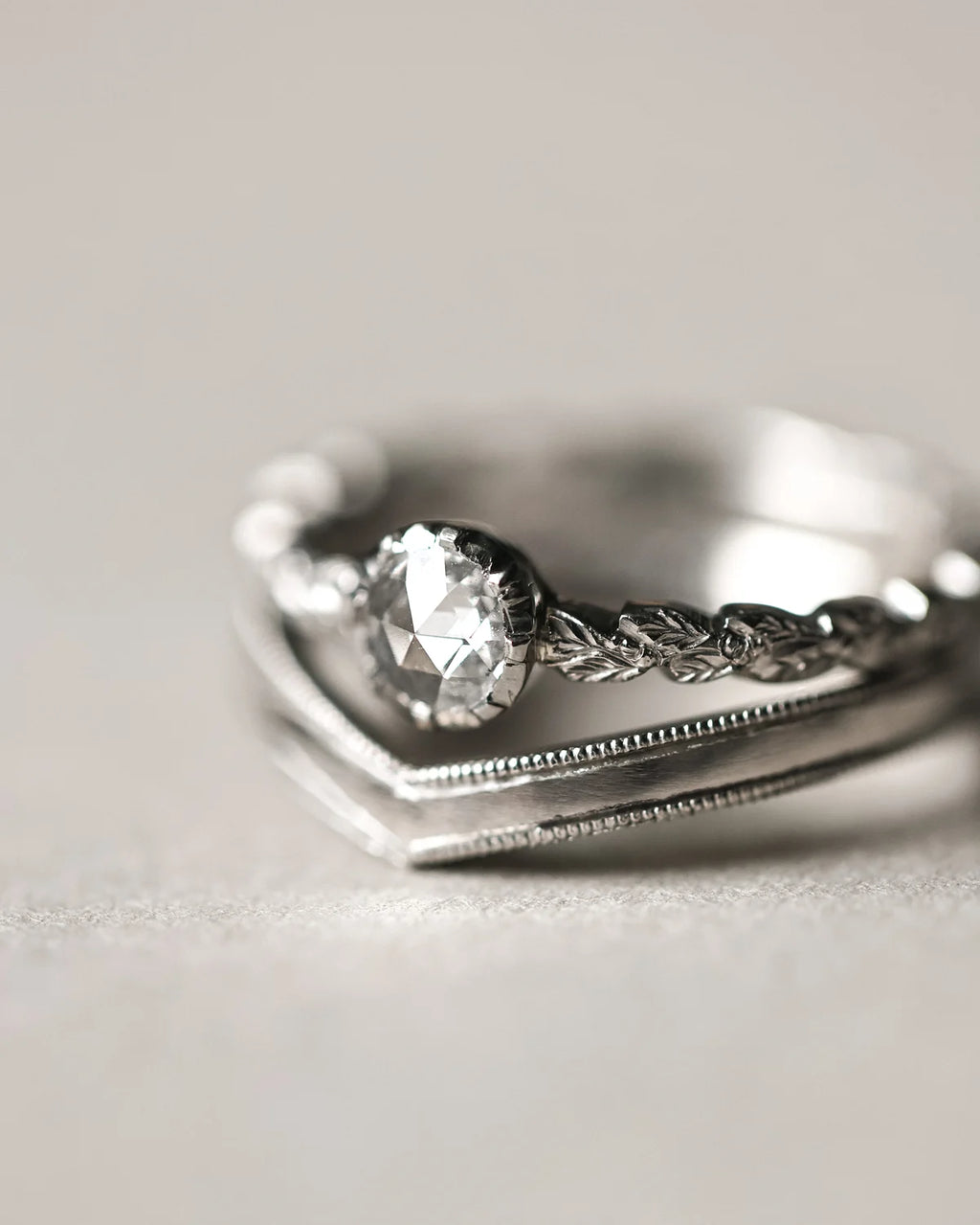 Platinum milled edge wishbone ring paired with rose-cut diamond ring