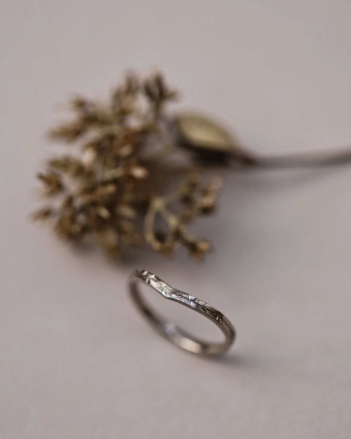Vertical view of white gold willow leaf engraved wishbone ring