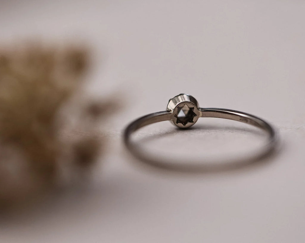 Soft focus view of champagne rose-cut diamond ring with dried flowers
