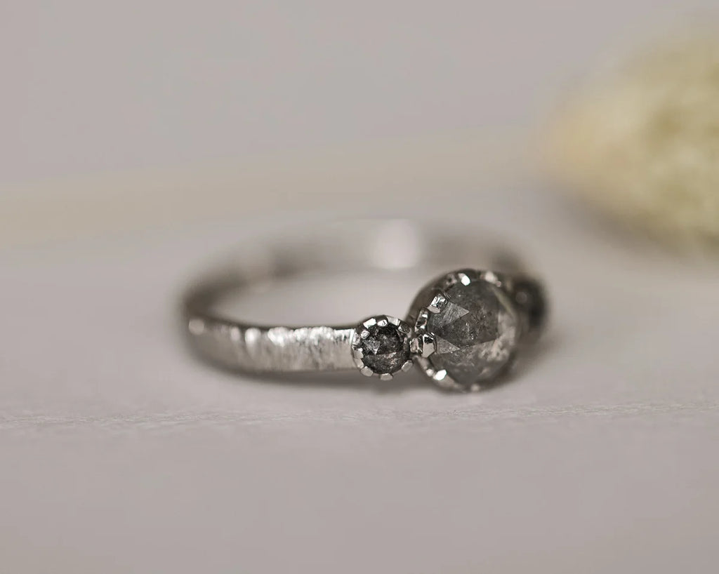 Side view of platinum salt and pepper diamond trilogy ring