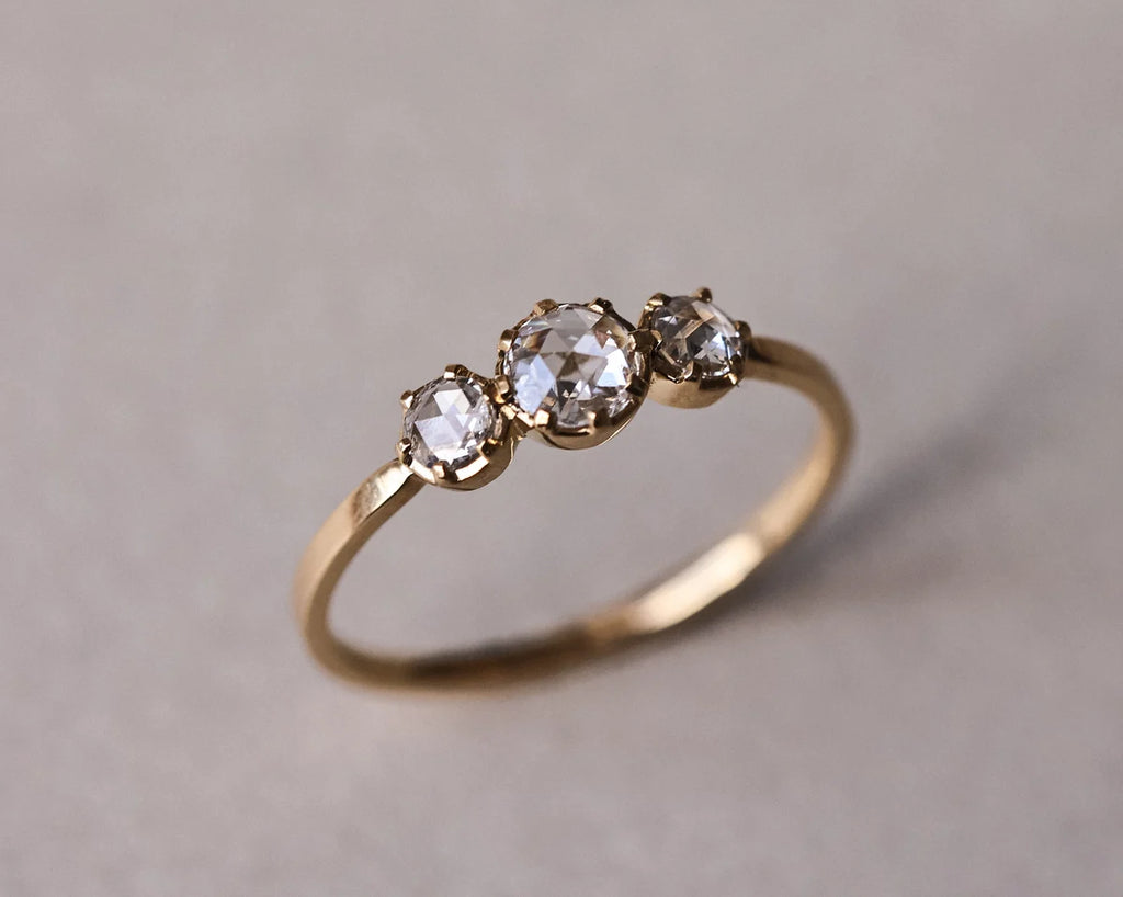 Angled view of yellow gold rose-cut diamond trilogy ring