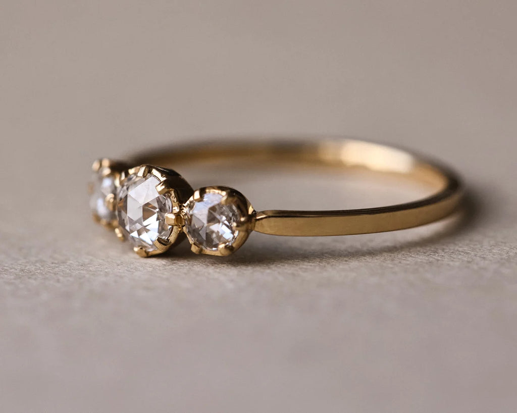 Side view of rose-cut diamond trilogy ring in yellow gold