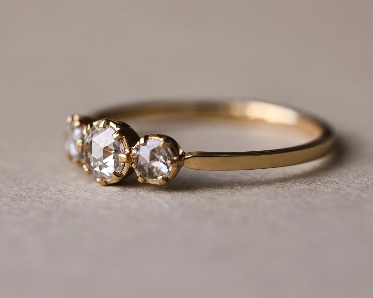 Side view of rose-cut diamond trilogy ring in yellow gold