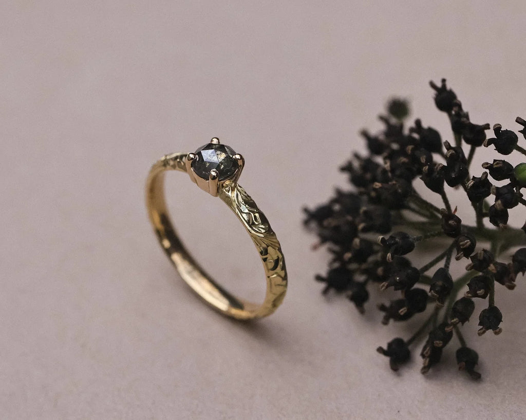 Editorial image of grey diamond floral ring with dark botanical styling