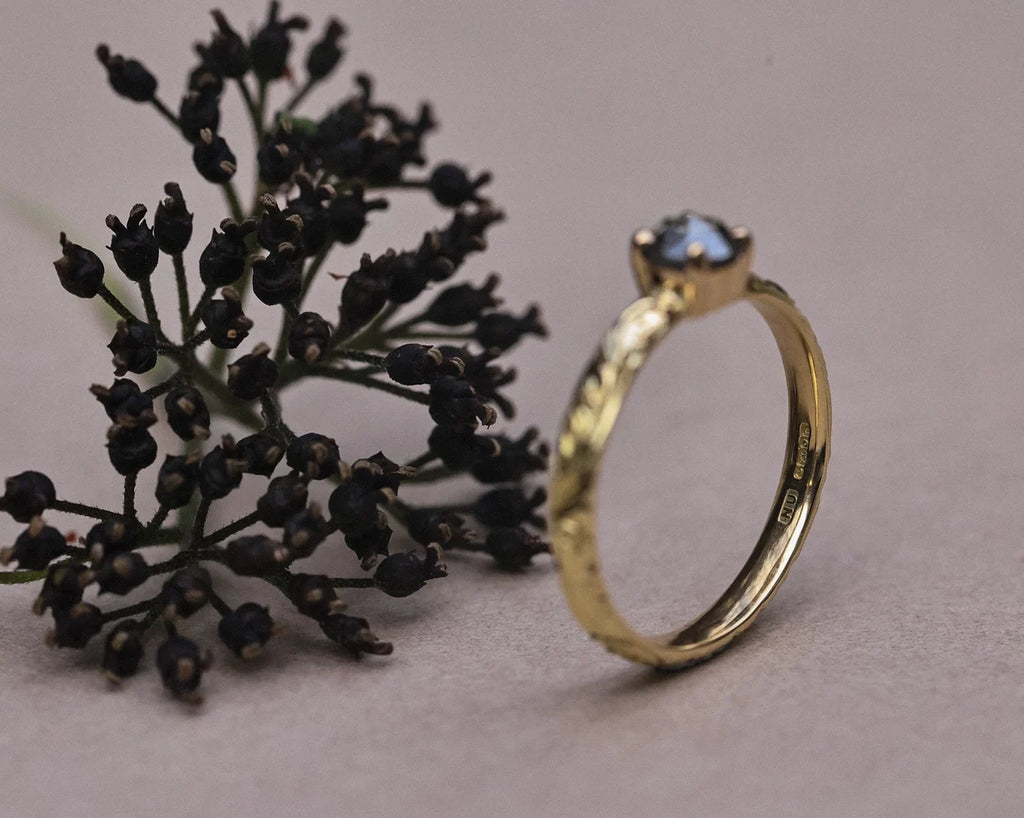 18ct yellow gold floral engraved ring styled with dark botanical detail