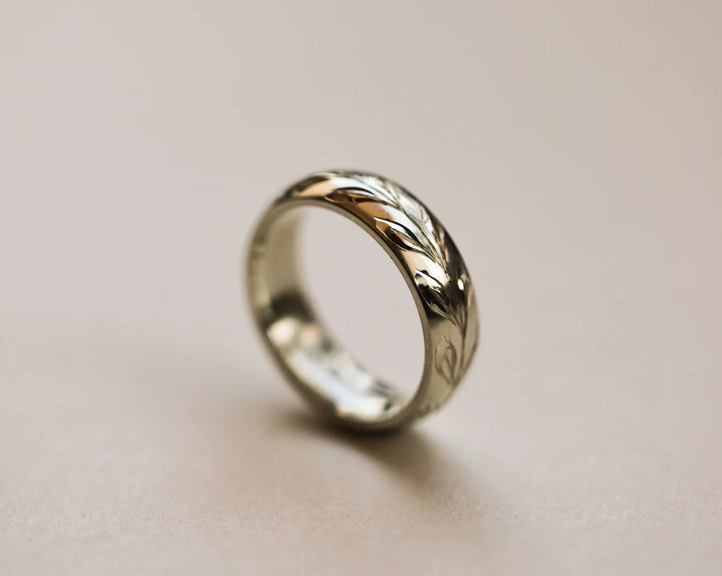 Side view of 18ct white gold olive leaf engraved court wedding ring