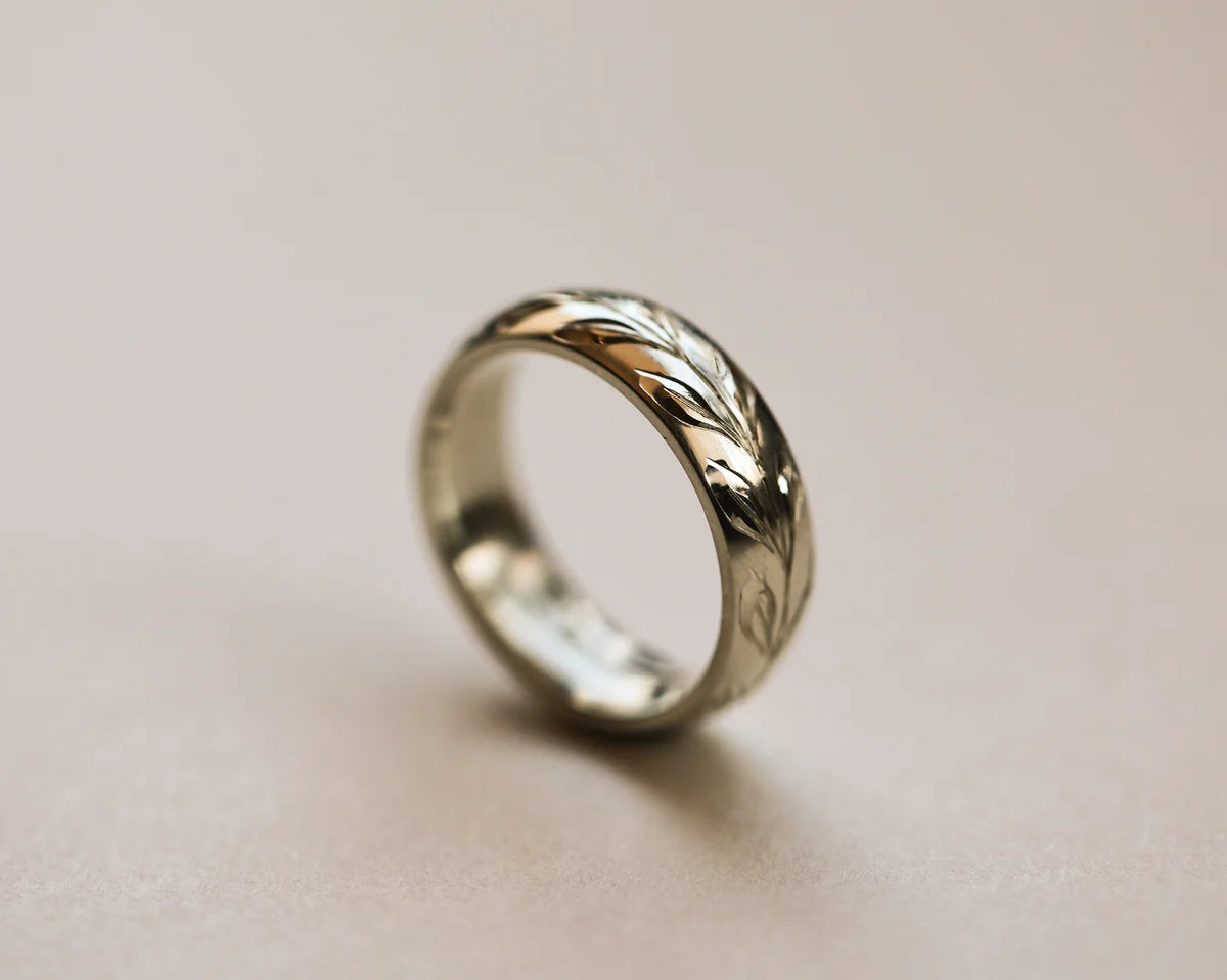 Side view of 18ct white gold olive leaf engraved court wedding ring