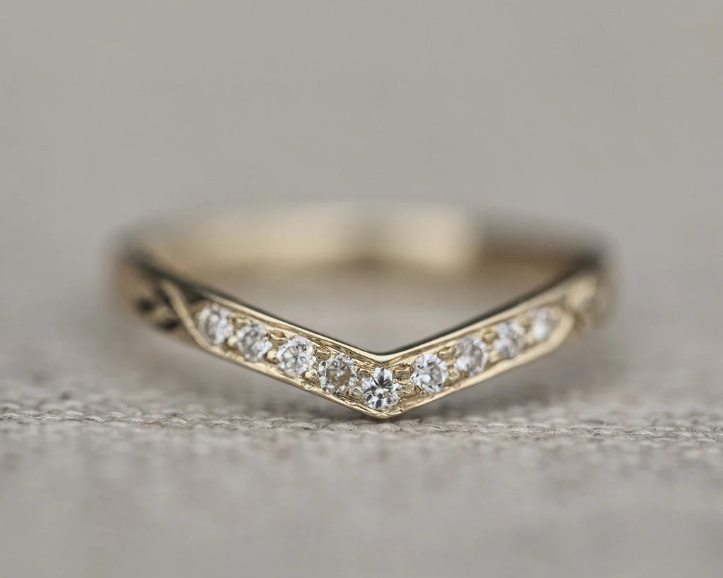 Close-up of white gold wishbone ring with pavé diamonds