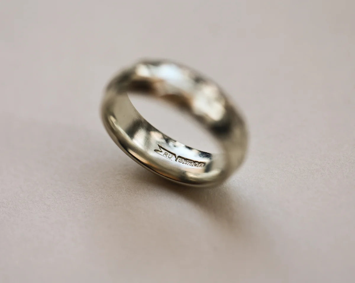 Angled view of handmade olive leaf engraved ring in 18ct white gold