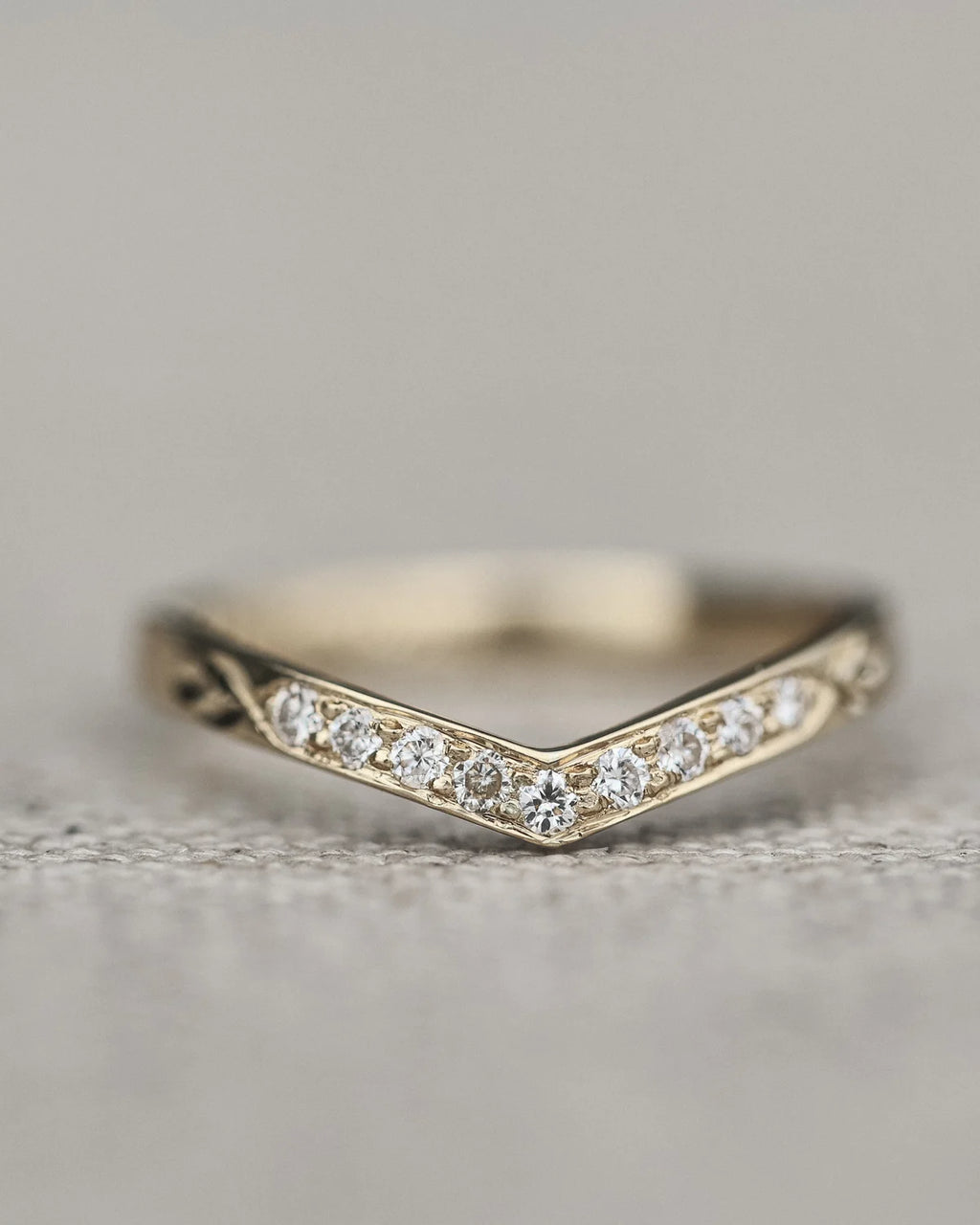 Detailed view of pavé diamond wishbone ring in white gold
