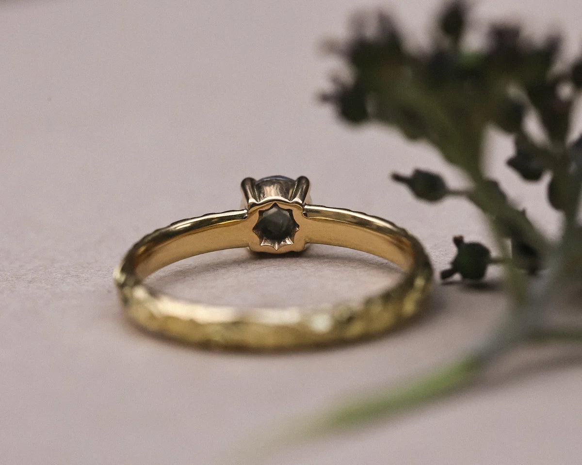 Rear profile of dark grey diamond ring showing engraved floral band