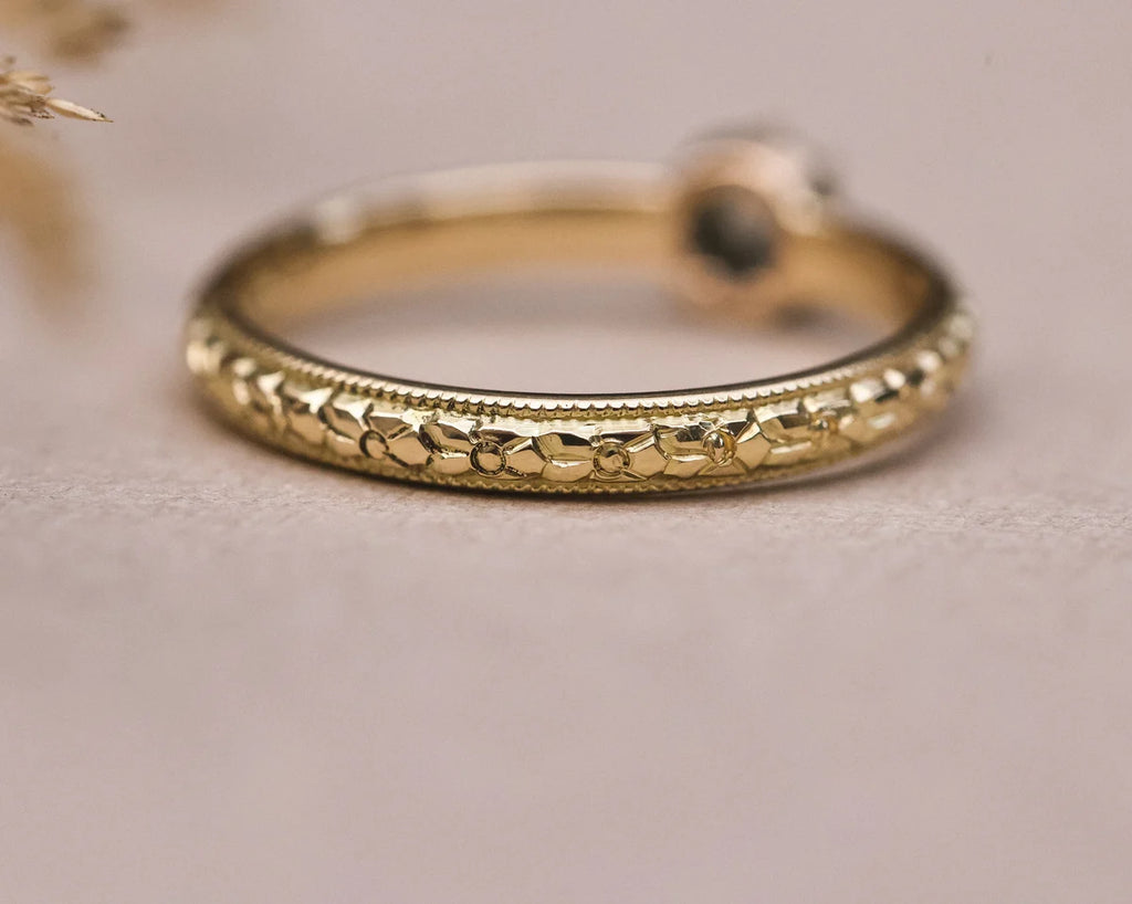 Detail of orange blossom engraved band in 18ct yellow gold