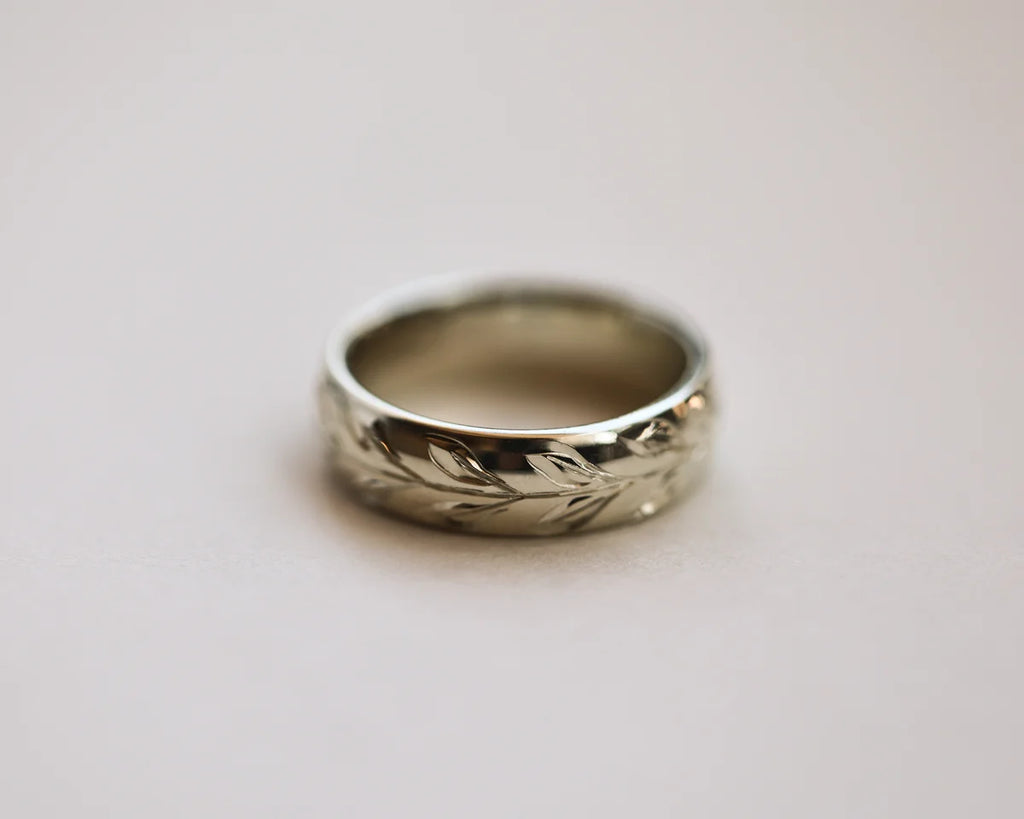 Front view of 6mm white gold wedding band with olive leaf engraving
