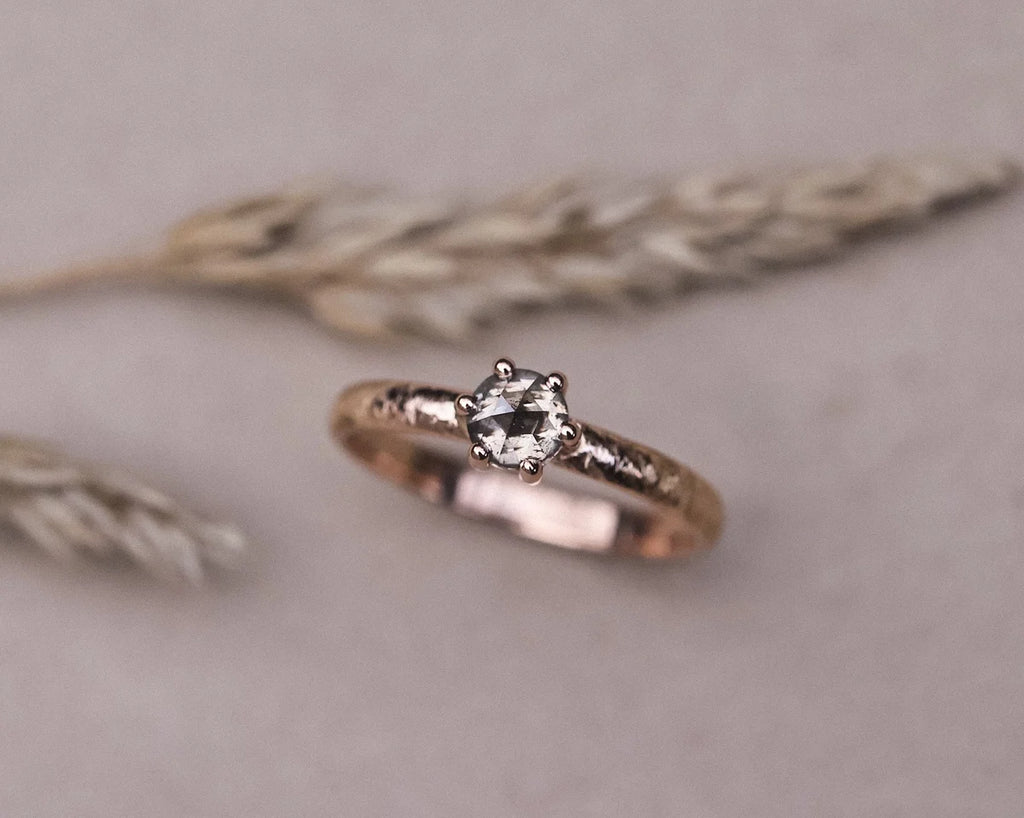 Angled view of 18ct rose gold horn texture ring with grey rose-cut diamond