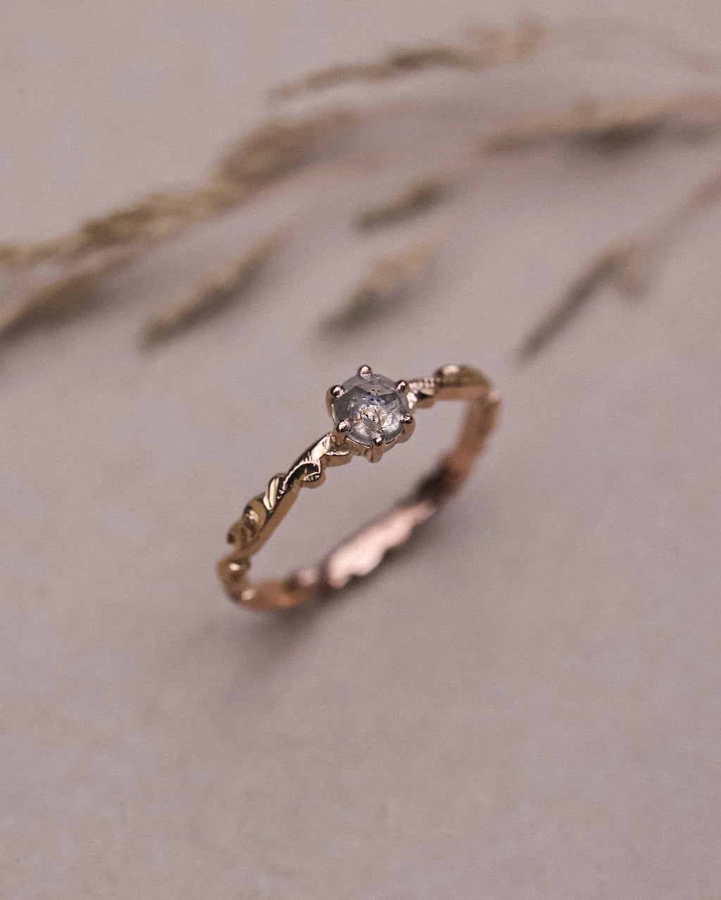 Angled close-up of pale grey rose-cut diamond floral ring