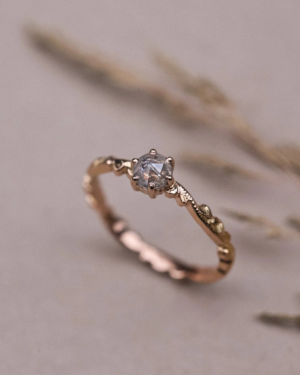 Editorial close-up of 18ct rose gold ring with pale grey rose-cut diamond