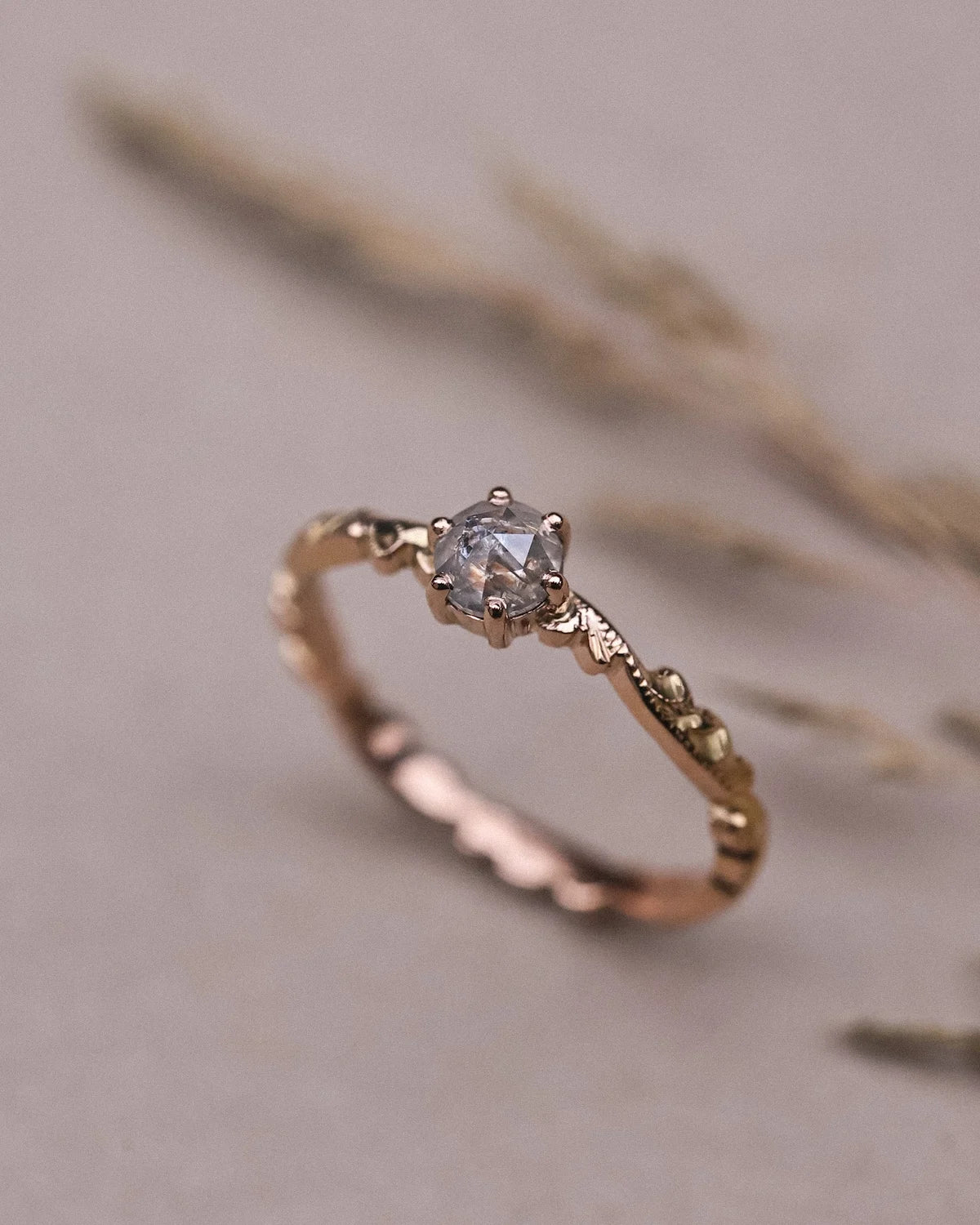 Editorial close-up of 18ct rose gold ring with pale grey rose-cut diamond