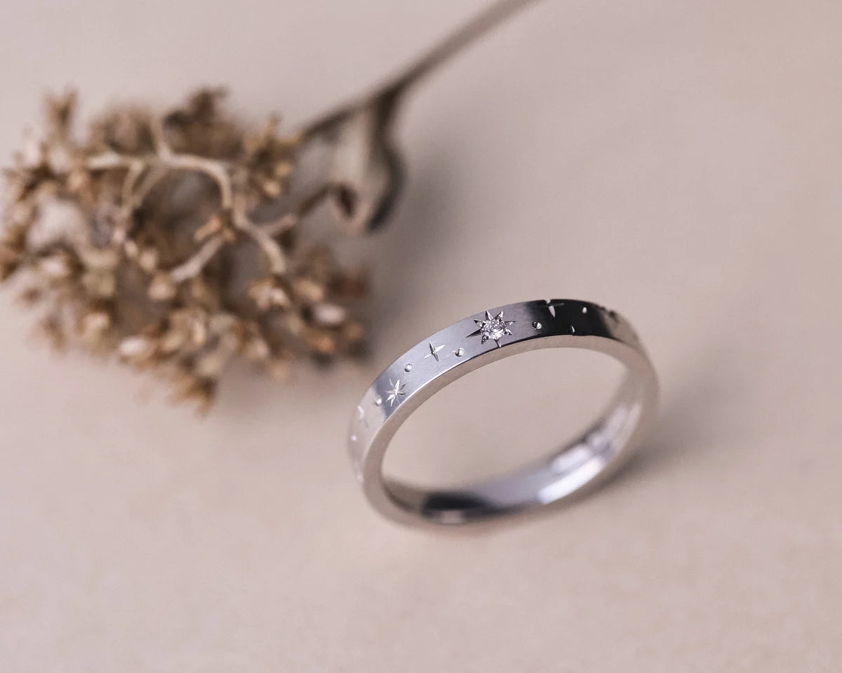 Angled view of platinum star set diamond eternity ring with botanical styling