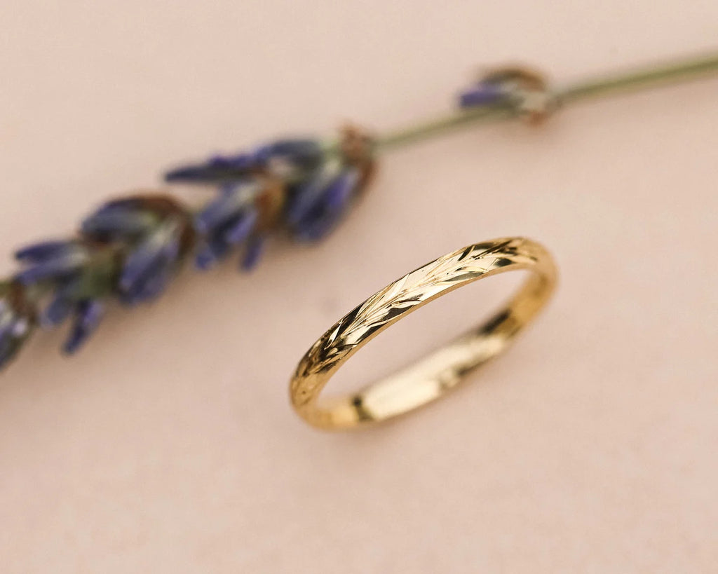 Angled view of 18ct yellow gold olive leaf wedding ring