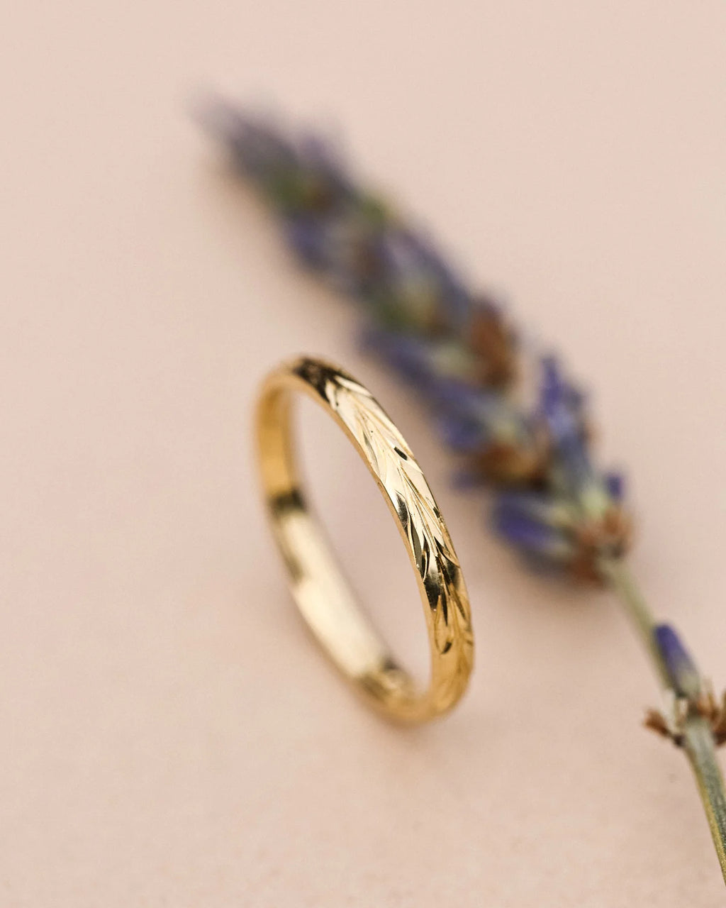 Vertical view of 2mm olive leaf engraved ring in yellow gold