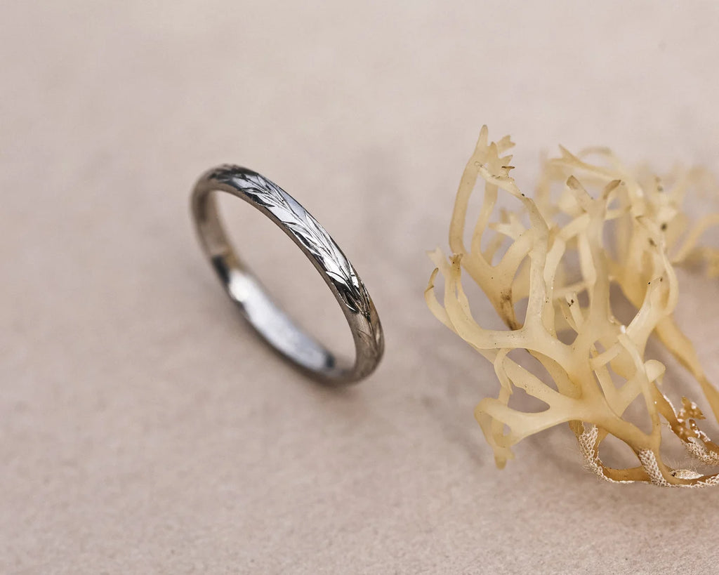 Vertical view of handmade platinum olive leaf engraved ring