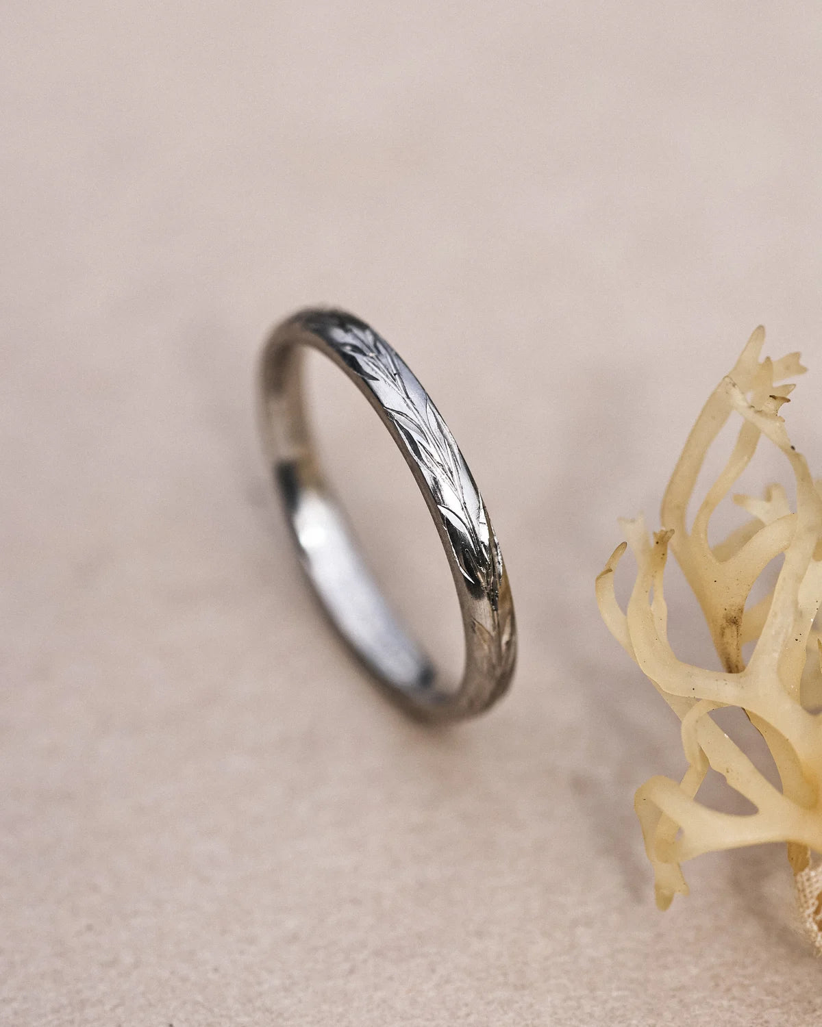 Side view of handmade olive leaf engraved ring in platinum