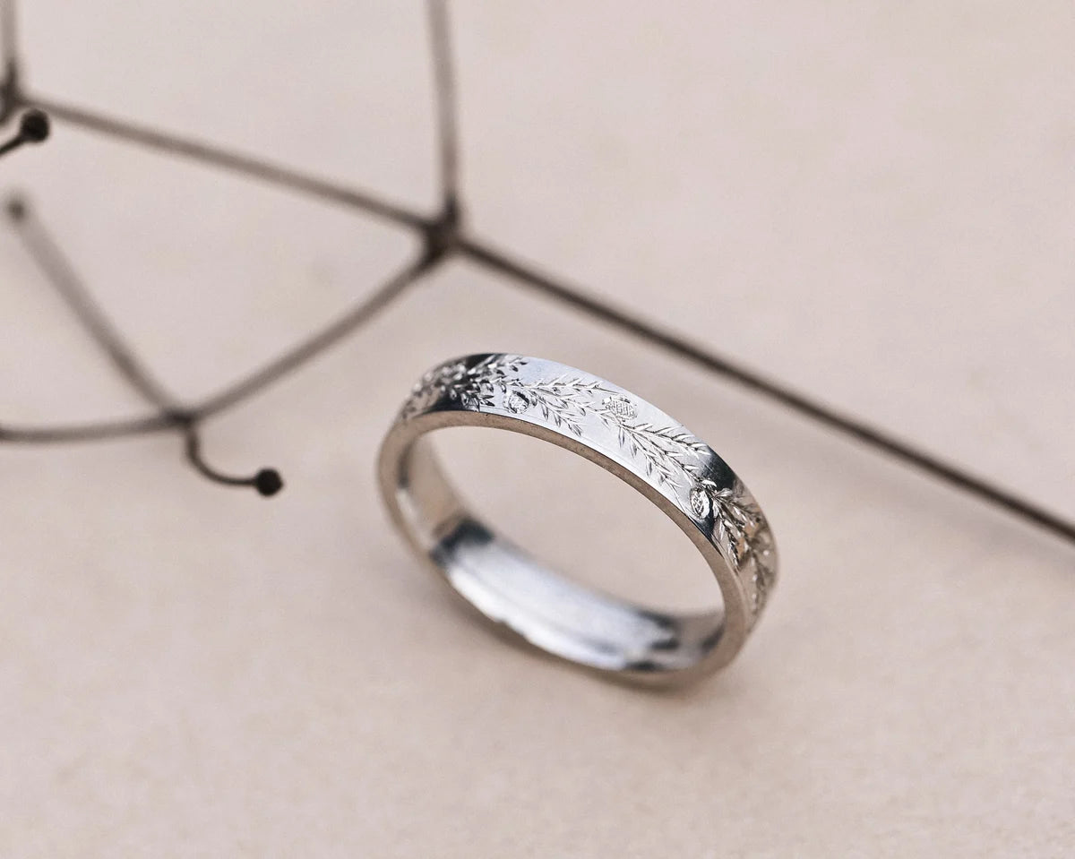 Handmade platinum wedding ring with engraved fir motif