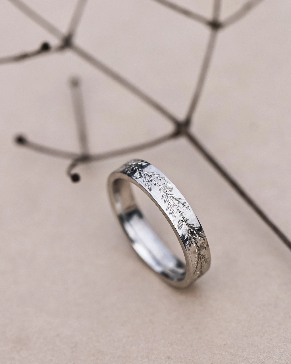 Platinum flat court wedding ring with fir engraving and botanical styling