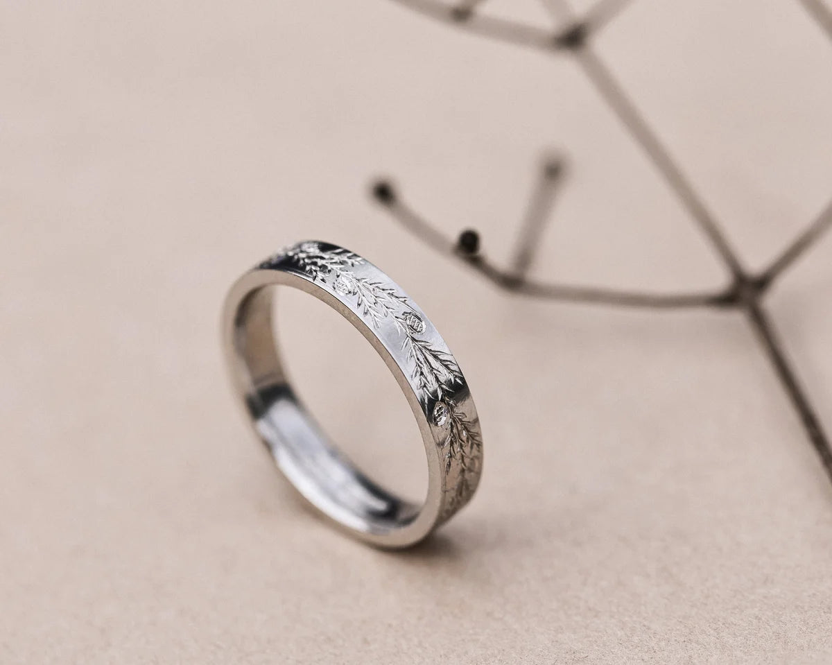 Side profile of platinum flat court wedding ring with fir detail