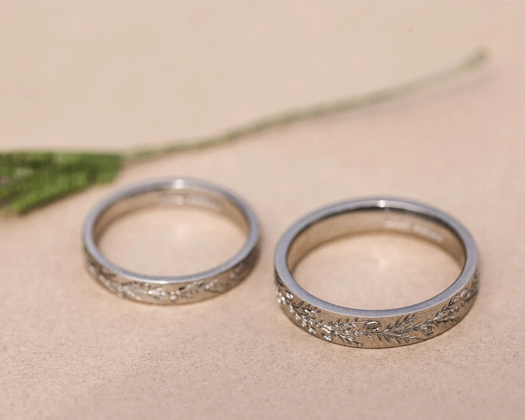 Matching platinum fir engraved wedding rings with botanical styling