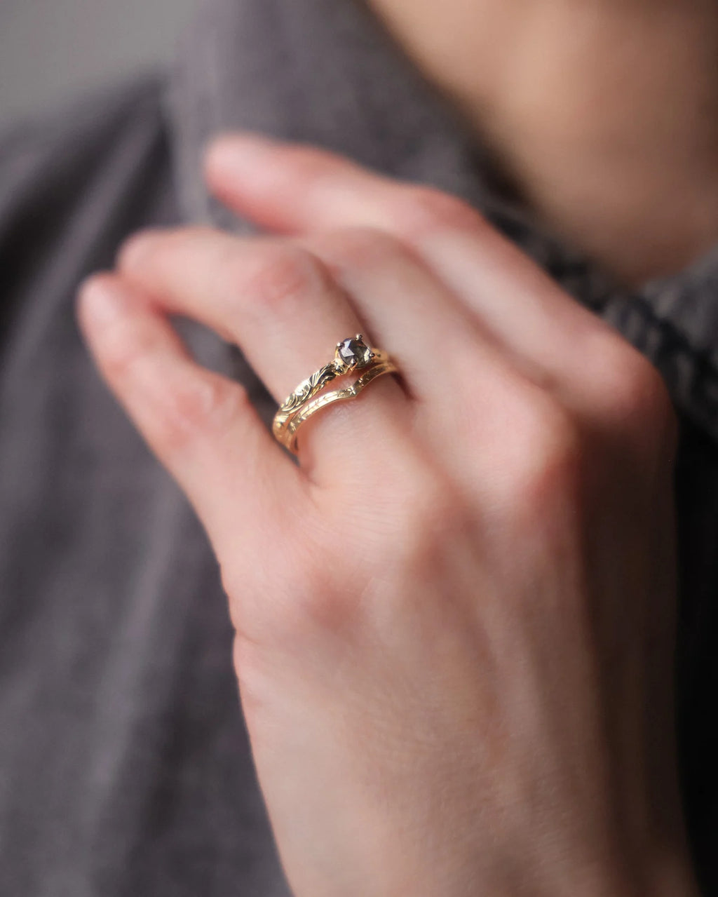 Grey rose-cut diamond floral ring worn on hand in soft natural light