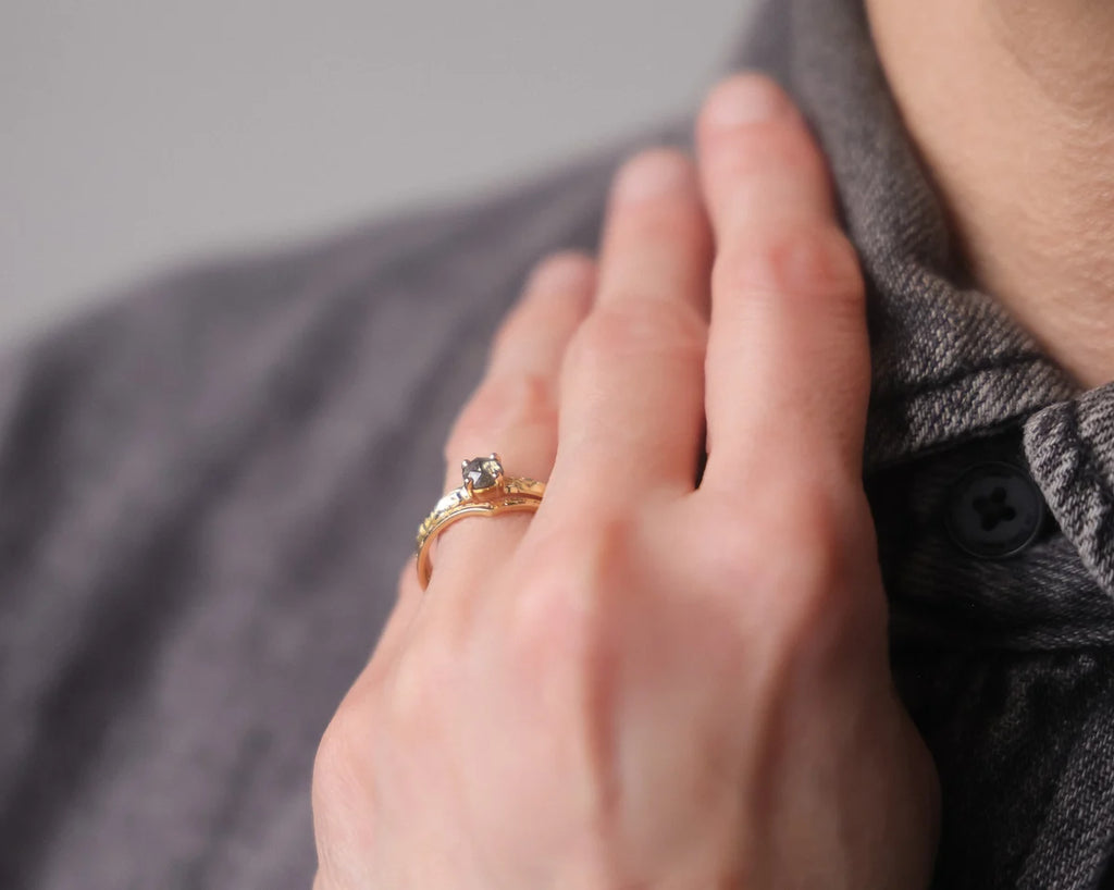 Dark grey rose-cut diamond floral ring worn on hand