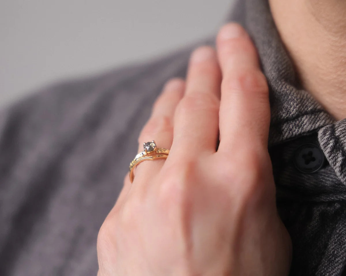 Dark grey rose-cut diamond floral ring worn on hand