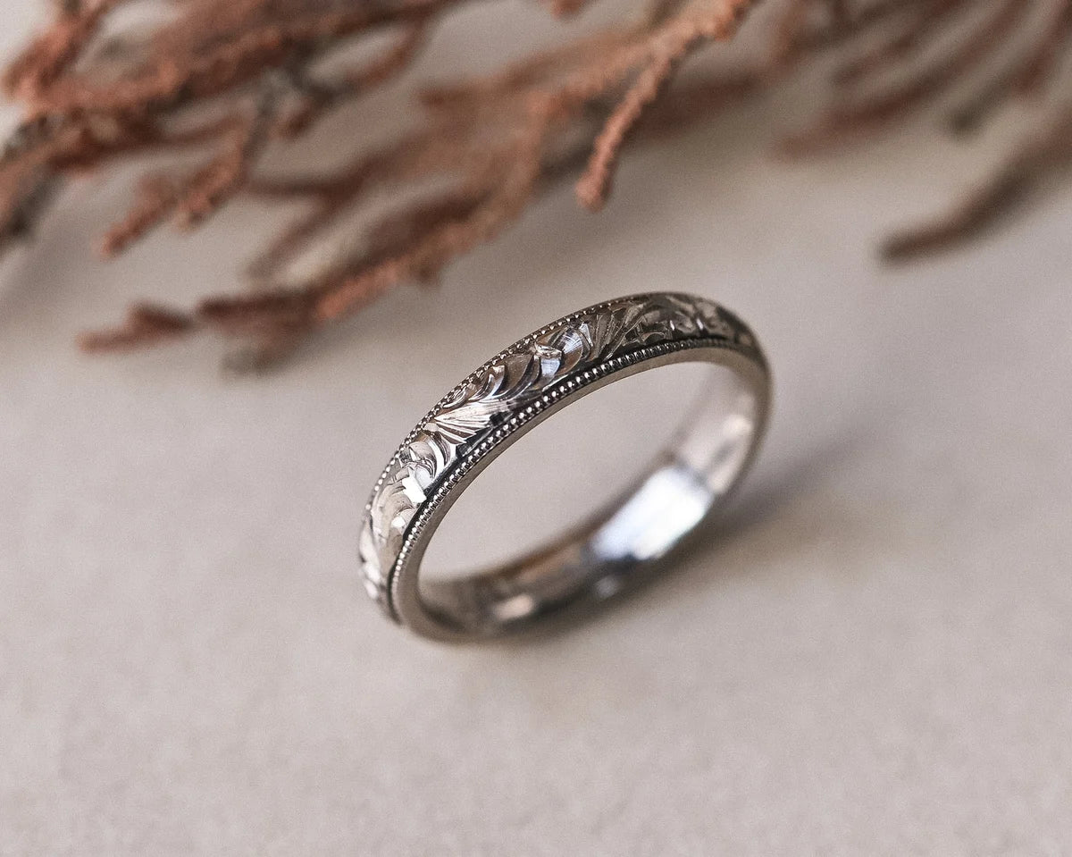 Angled view of 18ct white gold floral engraved wedding ring