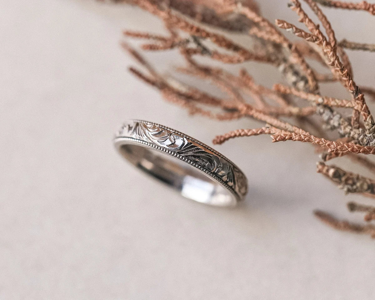 Side view of floral and milled edge wedding ring in 18ct white gold