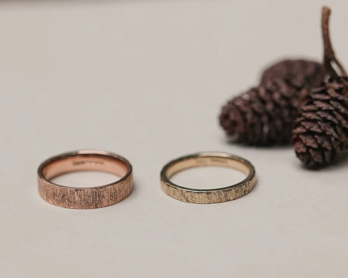 9ct rose gold horn texture ring shown beside yellow gold wedding band