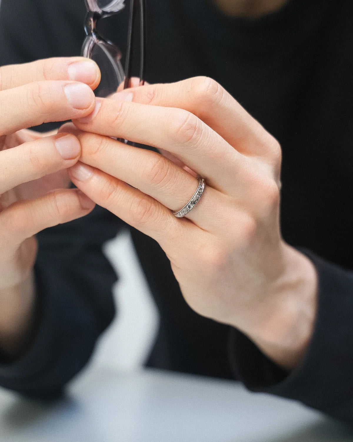 18ct white gold floral wedding ring worn while holding a vintage camera