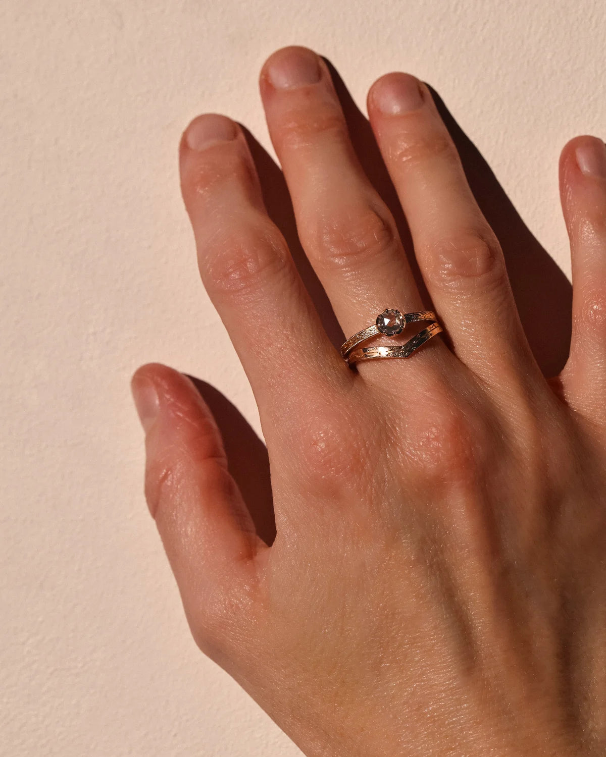 Brown-grey rose-cut diamond laurel ring worn on hand