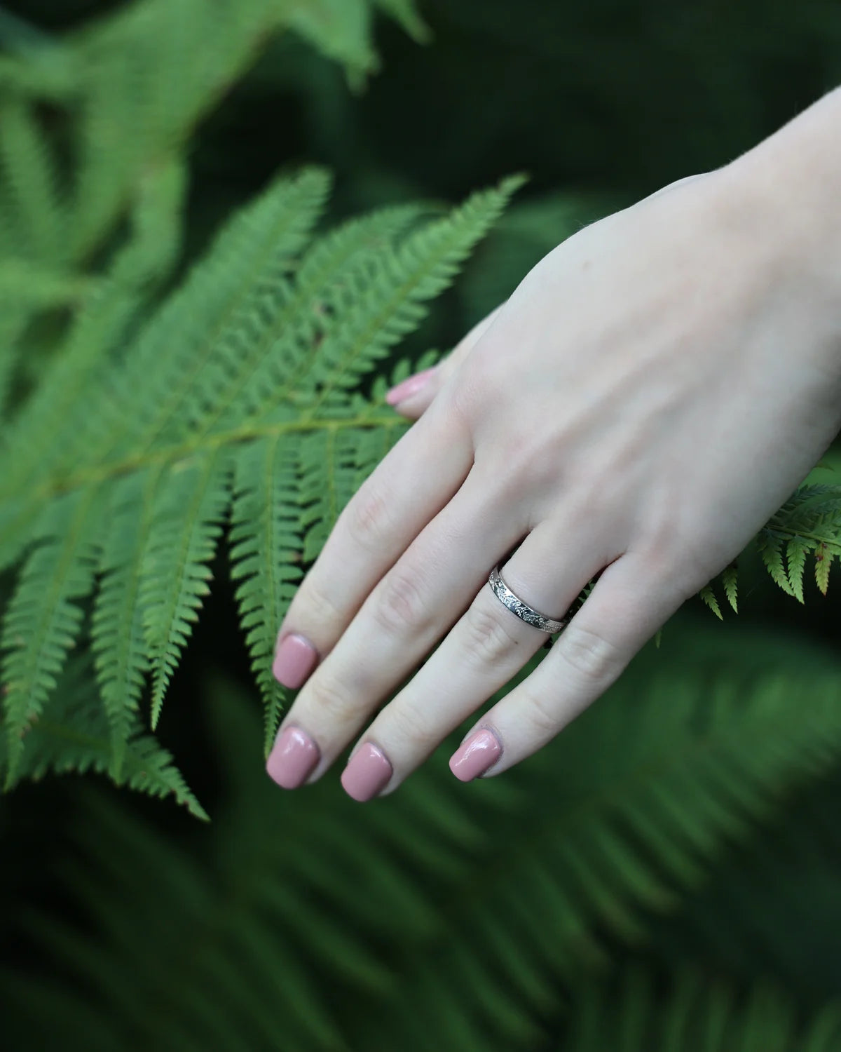 platinum wedding ring worn on hand engraved band